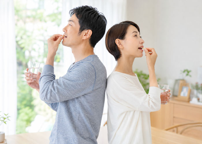 日常の爽やかな朝、お水と一緒にサプリメントを飲むイメージ画像